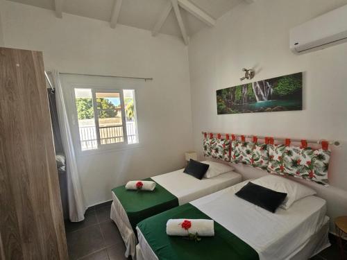 a bedroom with two beds and a window at Villa Fleur de Lys MAE in Morne-à-lʼEau