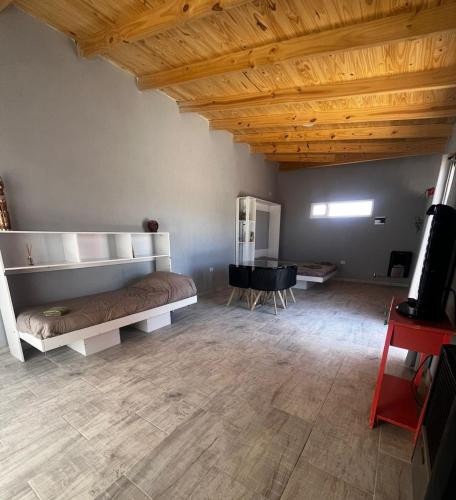 a bedroom with a bed and a desk and a piano at Monoambiente de Playa in Camarones