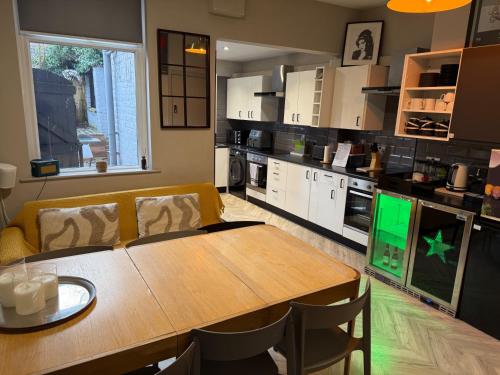 a kitchen with a wooden table and chairs in a room at Snooker Stay Near Crucible - 4 En-Suite Beds- in Sheffield