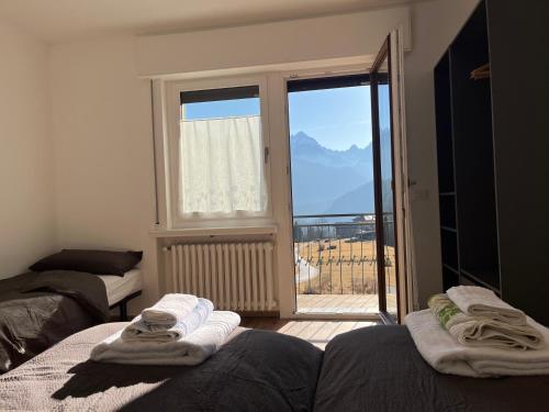 a room with two beds and a window with a view at Tra prati e monti - Dolomiti Bellunesi in Valle di Cadore