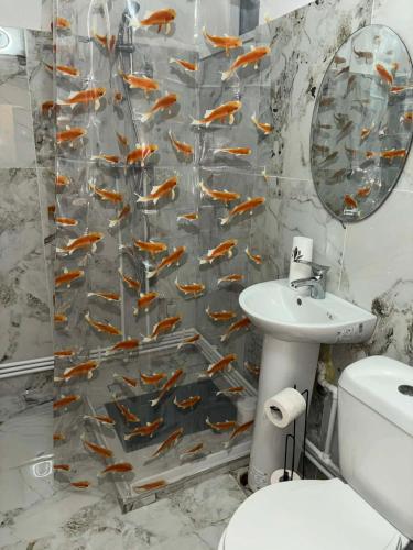 a bathroom with a shower curtain with a fish pattern at La Sibip in Târgu Neamț