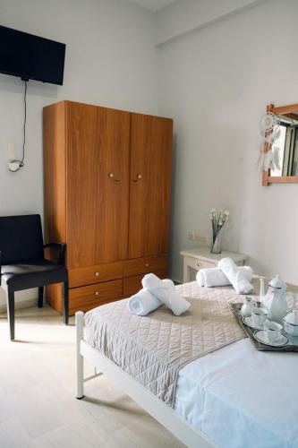 a bedroom with a bed and a wooden cabinet at Γκαρσονιέρα δίπλα στη θάλασσα. in Kómi