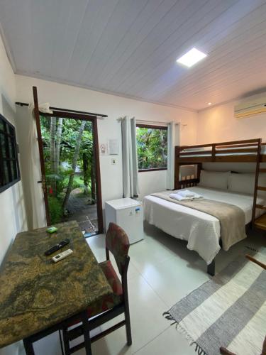 a bedroom with a bed and a table in it at LEGATUM POUSADA - Próx a BR 101 e Partage Shopping in Campos dos Goytacazes
