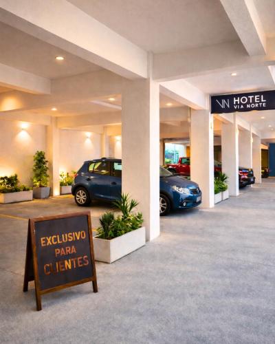 ein Schild vor einem Parkhaus mit Autos in der Unterkunft Hotel Vía Norte Inn - Nuevo - Estacionamiento gratis - Ubicación estratégica in Tuxtla Gutiérrez
