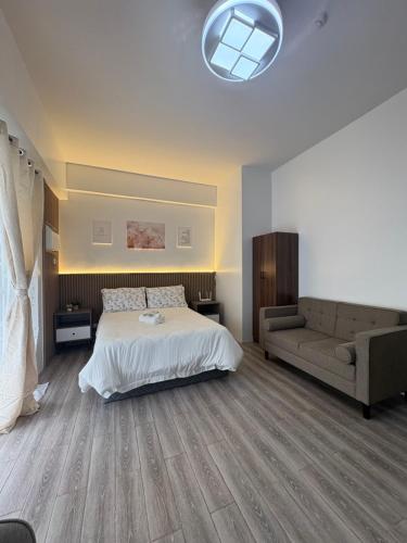 a bedroom with a bed and a couch at 128 C Amani in Lapu Lapu City