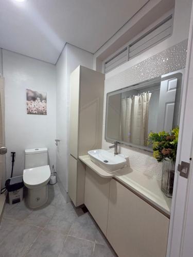 a white bathroom with a sink and a toilet at 128 C Amani in Lapu Lapu City