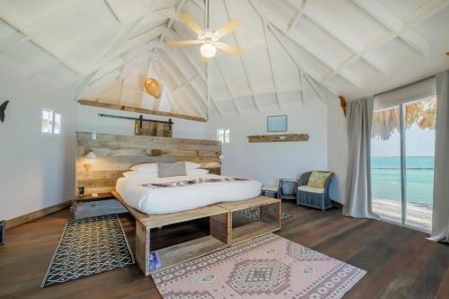 a bedroom with a bed and a ceiling fan at Thatch Caye Resort a Muy'Ono Resort in Hopkins