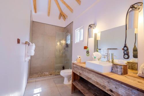 a bathroom with a sink and a toilet at Thatch Caye Resort a Muy'Ono Resort in Hopkins