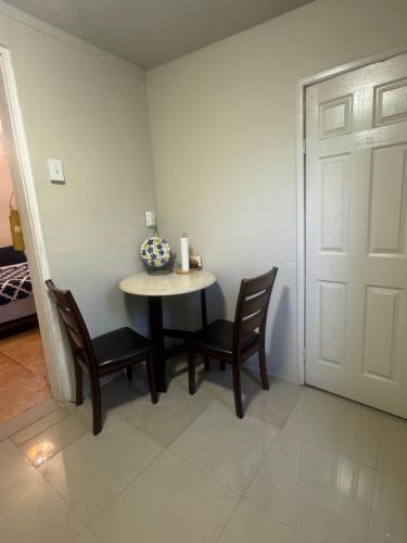a small table and chairs in a room with a door at *PRIVATE* Studio 5 minutes from LGA/ US Open in East Elmhurst