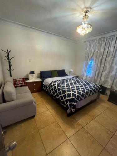 a bedroom with a bed and a couch in it at *PRIVATE* Studio 5 minutes from LGA/ US Open in East Elmhurst