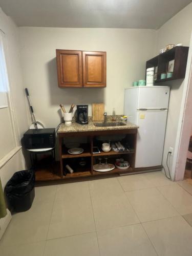 a kitchen with a counter and a white refrigerator at *PRIVATE* Studio 5 minutes from LGA/ US Open in East Elmhurst