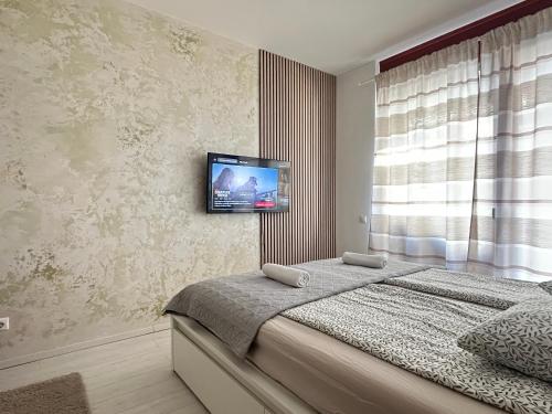 a bedroom with a bed with a television on the wall at Marina Panorama Apartment & Garage in Budapest