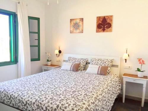 1 dormitorio con 1 cama grande y 2 mesas en Casita Blanca, Jardín del Sol 1, en Playa Blanca