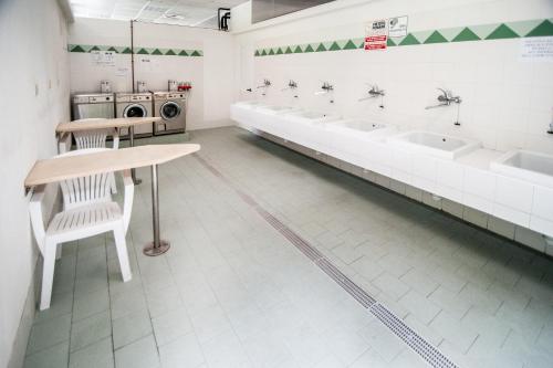 a public bathroom with sinks and a row of sinks and toilets at Villaggio Turistico Camping Cervino in Antey-Saint-André