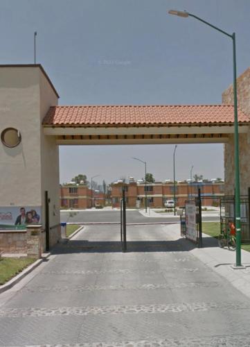 an empty parking lot with a gate and a street at Departamento Entero en el Sur Facturamod in Santa Gertrudis