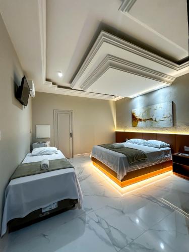 a large bedroom with two beds and a tv at Salinas House Hotel - Antigo Valley Hills Hotel in Salinas