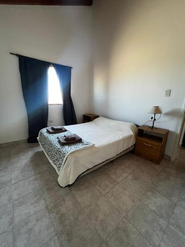 a bedroom with a bed and a table and a window at Cabañas de Mar - Calfu Huenu in Camarones
