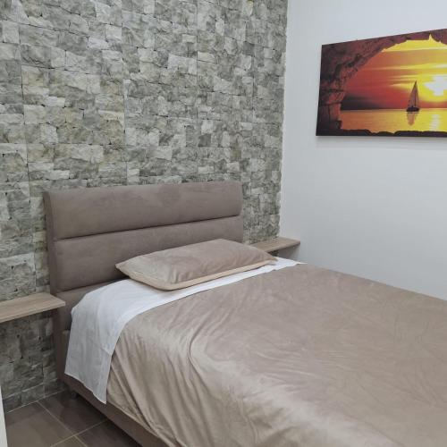 a bed in a bedroom with a stone wall at Casa Bruno in Palermo