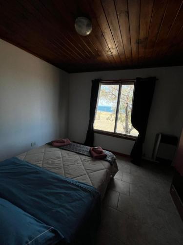 a bedroom with a bed and a window at Cabañas de Mar - Calfu Huenu in Camarones