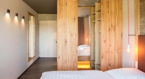 a bedroom with a wooden door leading to a bed at Landgasthof Pappelkrug in Halle Westfalen