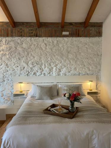 a bedroom with a bed with a tray of flowers on it at Bahía de Pedreña 2 in Pedreña