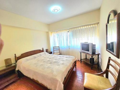 a bedroom with a bed and a television at La Perla Mar y Sol in Mar del Plata