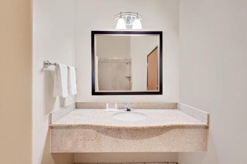 a bathroom with a sink and a mirror at Sonesta Essential Hotels Odessa in Odessa