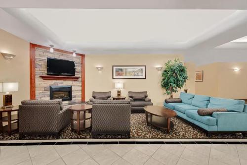 a living room with blue couches and a fireplace at Sonesta Essential Hotels Odessa in Odessa