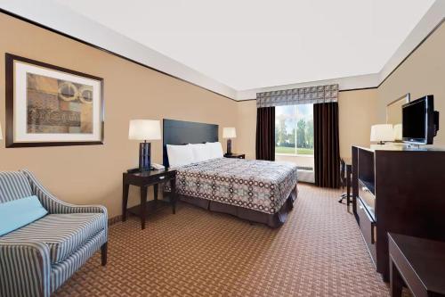 a hotel room with a bed and a couch at Sonesta Essential Hotels Odessa in Odessa