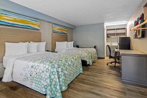 a hotel room with two beds and a desk at HomeTowne Studios by Red Roof Athens, TN in Athens
