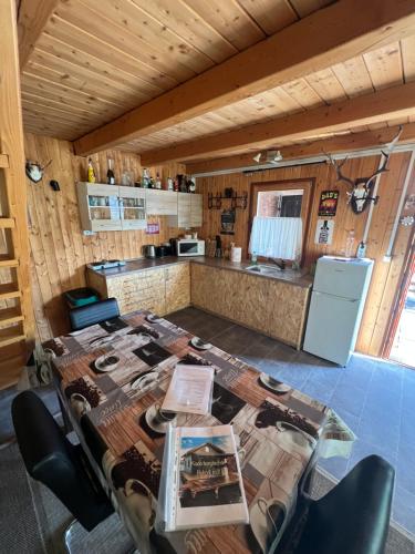 a room with a table and a kitchen with a counter at Bokodi üdülő és horgászházak in Oroszlány