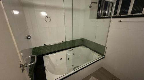 ein Badezimmer mit Badewanne und Glastür in der Unterkunft Hotel Arsenal in São Gonçalo