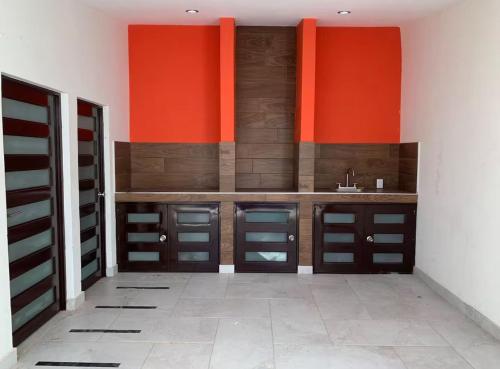 a bathroom with orange and brown cabinets and a sink at Casa Chonita in Tecuala
