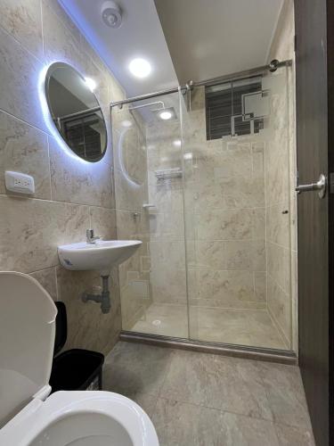 a bathroom with a shower and a toilet and a sink at Las Palmas Paraíso Ricaurte in Ricaurte