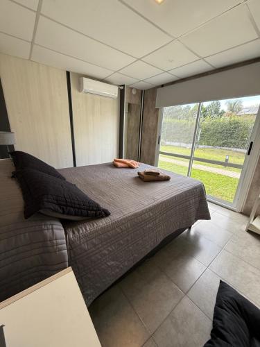 a large bed in a room with a large window at Piedras Moras cabañas in Almafuerte