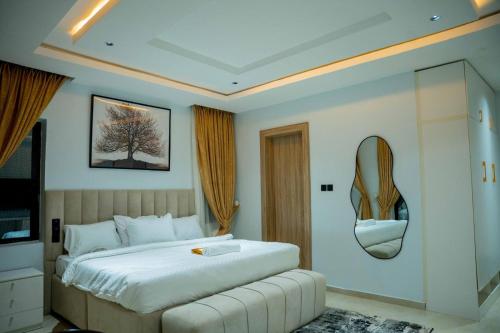 a bedroom with a bed and a mirror on the wall at Nirvana City Hotel in Benin City