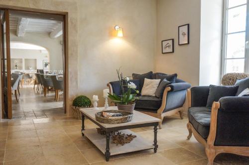 a living room with blue couches and a table at Boutique Hôtel La Villa MONTESQUIEU in Laudun