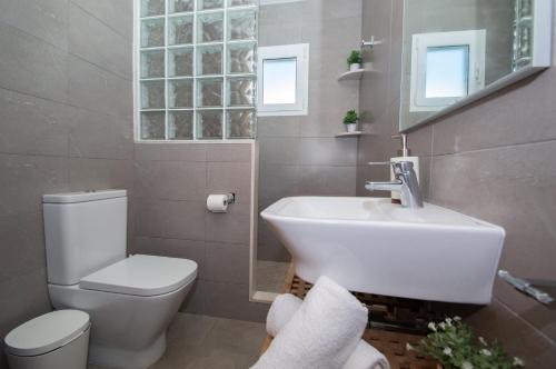 a bathroom with a white toilet and a sink at Villa Can Canaleta by Sonne Villas in Cala Galdana