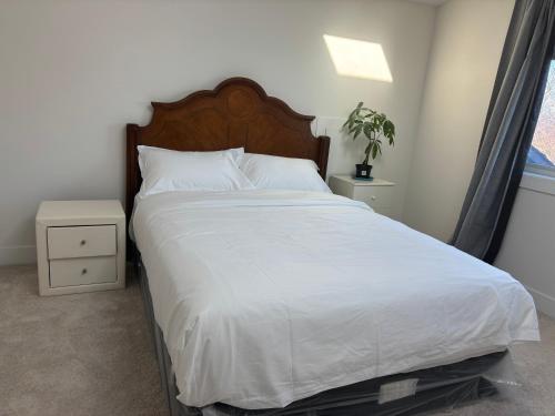 a bedroom with a large bed with white sheets at Comfortable Private Room in a Shared Home in Richmond