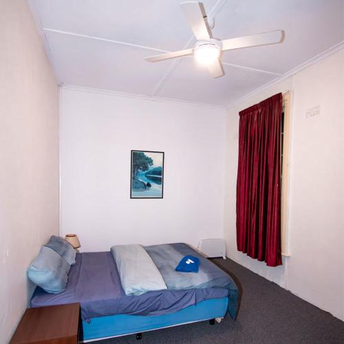 a bedroom with a bed and a ceiling fan at Commercial Hotel in Birchip