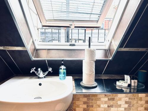 a bathroom with a sink and a window at Guest And The City in Brighton & Hove