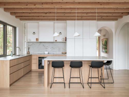 a kitchen with a large island with black bar stools at Wild Pond Villa in Mansonville