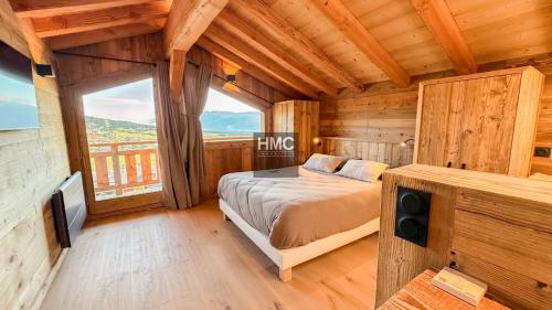 a bedroom with a bed and a large window at Agane skis aux pieds jacuzzi et vue montagne in Les Angles