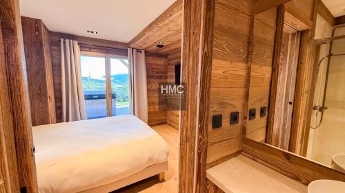 a bedroom with a bed and a bathroom with a mirror at Agane skis aux pieds jacuzzi et vue montagne in Les Angles