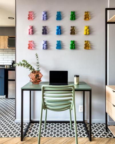 a table with a chair and a laptop on a wall at ULIV Condesa in Mexico City