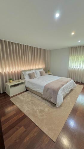 a bedroom with a large bed and a rug at Villa Branco - Private Pool & Garden in Barcelos