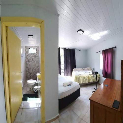 a bedroom with a bed and a desk in a room at Pousada Shalom in Barracão