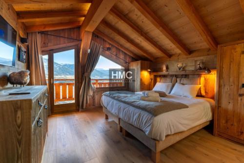 a bedroom with a bed and a large window at Bliss luxe pyrénéen jacuzzi et vue montagne in Bolquere Pyrenees 2000