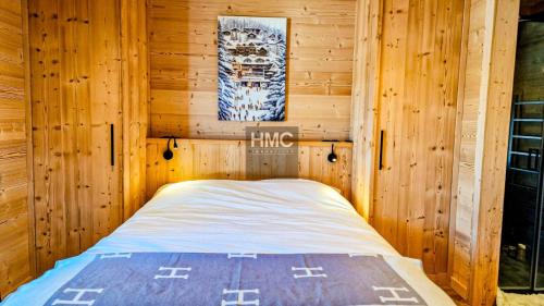 a bedroom with a bed in a wooden cabin at Ski Bob accès direct pistes jacuzzi privé in Bolquere Pyrenees 2000