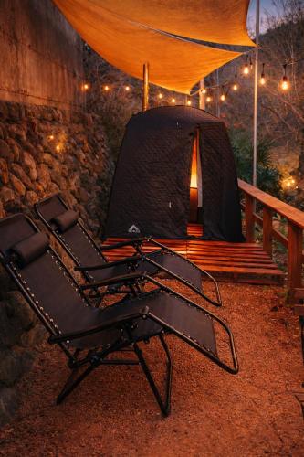 a black reclining chair in front of a tent at 川辺の宿-Kawabe-BBQ-川遊び in Hanno
